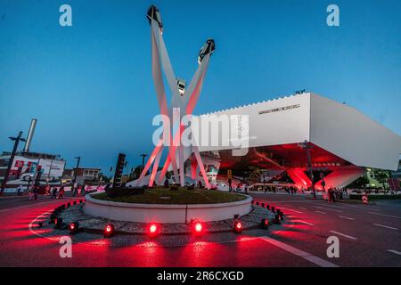 Stuttgart, Deutschland. 08. Juni 2023. Der Porscheplatz vor dem Porsche-Museum wird zur Blue Hour für die feierliche Veranstaltung, die 75 Jahre Porsche-Sportwagen feiert, farbenfroh beleuchtet. Kredit: Christoph Schmidt/dpa/Alamy Live News Stockfoto