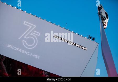 Stuttgart, Deutschland. 08. Juni 2023. Ein älterer Porsche 911 hängt vor einer Illustration von „75 Jahre Porsche“ im Porsche Museum. Kredit: Christoph Schmidt/dpa/Alamy Live News Stockfoto