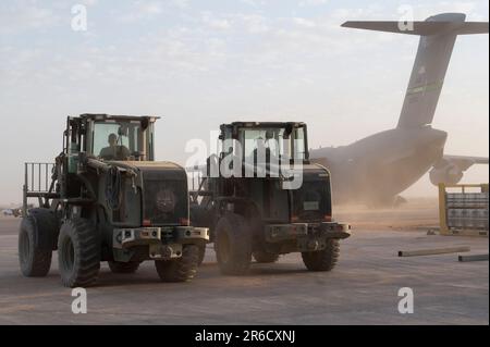 USA Air Force Airmen, die dem 724. Expeditionary Air Base Staffel Logistics Readiness Flug zugeteilt sind, bereiten Sie sich vor, Fracht von einem C-17 Globemaster III auf der Air Base 201, Niger, am 26. April 2023 zu entladen. 724. EABS LRF umfasst viele Bereiche wie Fahrzeugwartung, Betriebshalle von Flugterminals und Transport auf dem Boden. (USA Air Force Photo von Senior Airman Marcus Hardy-Bannerman) Stockfoto