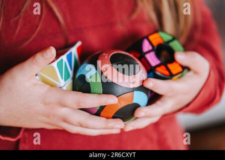 Puzzles verschiedener Formen in Kinderhänden Nahaufnahme Lernspielzeug. Puzzles und Konstruktoren Konzept.Spiel zur Problemlösung.Runde und Stockfoto