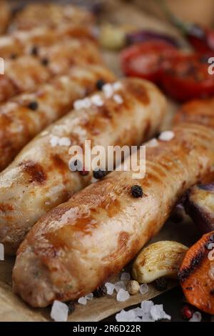 Leckere gegrillte Würstchen auf Holzbrett, Nahaufnahme Stockfoto