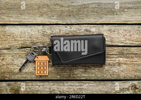 Ledertasche mit Schlüssel auf altem Holztisch, Draufsicht Stockfoto