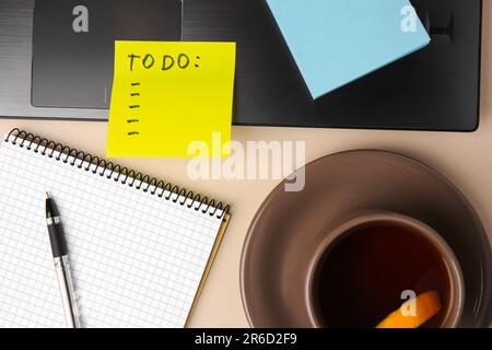 Notizen aus Papier, Notizbuch und Laptop auf beigefarbenem Tisch, flach liegend Stockfoto