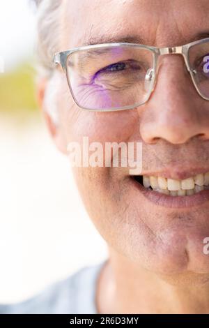 Nahaufnahme eines weissen Seniorenmannes mit Brille, die lächelt und in die Kamera schaut Stockfoto