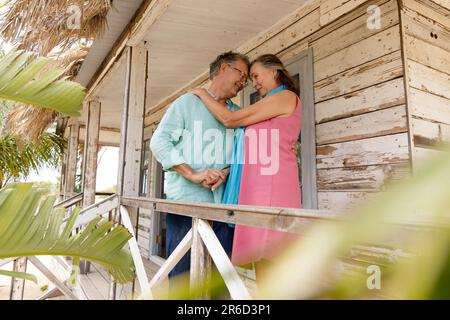 Ich liebe es, dass sich der weiße ältere Mann und die Frau umarmen und sich anschauen, während sie auf dem Balkon stehen Stockfoto