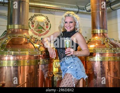 PRODUKTION - 30. Mai 2023, Brandenburg, Fürstenwalde: Steffi Landerer, Sänger und künftiger Bierbotschafter, steht mit einem Bier in den Braukesseln der Rathausbrauerei GmbH im Keller des alten Rathauses von Fürstenwalde. Ein prominenter Bierbotschafter wirbt seit 2017 für die regionalen Mikrobrauereien und Pubs Brandenburgs. Zuvor übernahmen Männer den Zweijahresposten. Mit Sänger Steffi Landerer aus Fürstenwalde wird es nun zum ersten Mal einen Bierbotschafter geben. Sie wird am 17. Juni ausgewählt. (Zu dpa: Vom Singen des 'Bierathleten' zum repräsentativen Bierbotschafter) Foto: Patrick Pleul/dpa Stockfoto