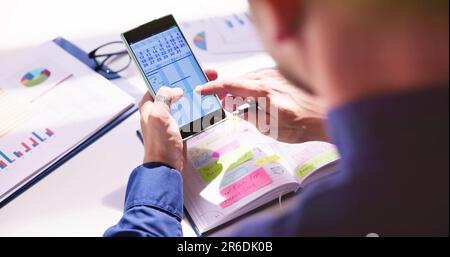Geschäftsmann Holding Handy mit Gantt App und Kalender Schreiben Zeitplan im Tagebuch mit Stift Stockfoto