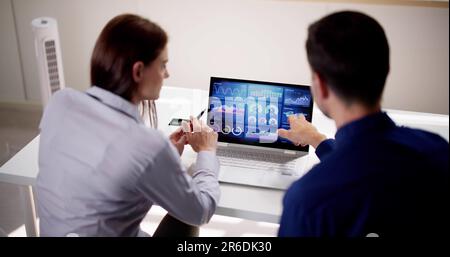 Zwei Analytiker, die KPI-Dashboard auf einem Laptop verwenden Stockfoto
