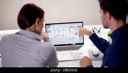 Zwei Analytiker, die KPI-Dashboard auf einem Laptop verwenden Stockfoto
