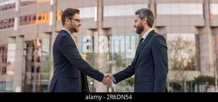 Zwei Geschäftsmänner geben sich die Hand. Zwei Geschäftsleute kümmern sich um Handschlag im Freien. Stockfoto