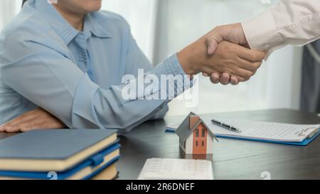 Immobilienmakler, der dem Kunden nach Vertragsunterzeichnung die Hand schüttelt und einen Geschäftsvertrag über die Übertragung des Eigentumsrechts abgeschlossen hat. Mann Broker makler Immobilien Stockfoto