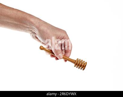 Männerhand mit Holzhonigstäbchen isoliert auf weißem Hintergrund. Honigstifter, Platz für Text Stockfoto