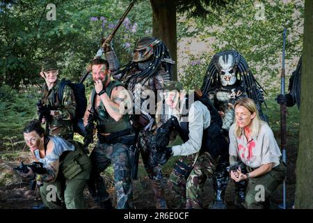 HARROGATE, GROSSBRITANNIEN - 3. JUNI 2023. Eine Gruppe Cosplay-Freunde, verkleidet als Alien Predator und Arnold Schwarzenegger aus der Filmreihe in Realistic CO Stockfoto