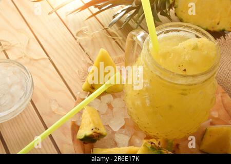 Details von frisch zubereiteter Ananascreme mit Obst und zerstoßenem Eis auf einem Holztisch. Erhöhte Aussicht. Horizontale Zusammensetzung. Stockfoto