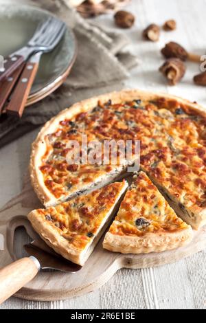 Quiche – Offene Torte mit Morchel-Pilzen, Zwiebeln und Mozzarella-Käse auf Holzbrett Stockfoto