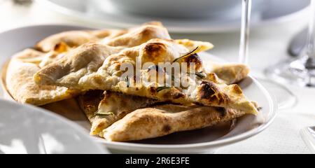 Frisches warmes Naan-Brot, geschnitten und auf einem Teller serviert. Stockfoto