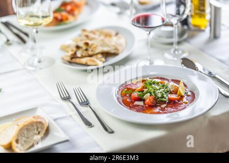 Perfekt gedeckter Tisch in einem italienischen Restaurant mit Carpaccio, Bruschetta und Pizza-Fladenbrot als Vorspeise. Stockfoto