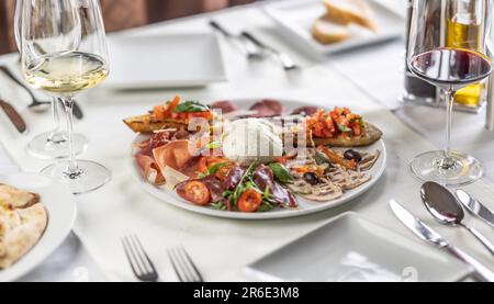 Italienische Antipasti-Vorspeise für mehr Leute, mit verschiedenen Arten von Speisen auf einem Teller. Stockfoto