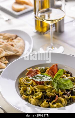 Orekchiette-Pasta mit grünem Genoesischem Pesto und Tiroler Fleck mit Basilikumblättern. Stockfoto