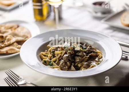 Tagliatelle mit italienischer Wurst und Wildpilzen. Stockfoto