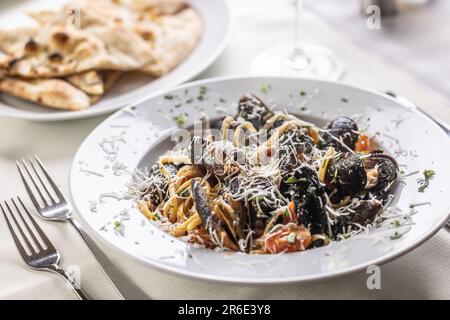 Liguine con cozze e Pecorino romano, italienische Pasta mit Muscheln und Käsereiben. Stockfoto