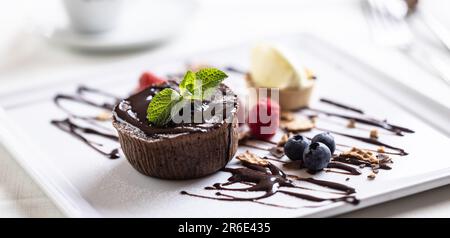 Schokoladenfondant mit Eiscreme, Beeren und Schokoladendekoration. Stockfoto