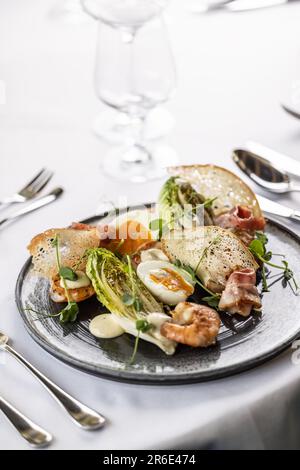 Moderne Version eines Gemüsesalats mit Garnelen, serviert in einem eleganten Restaurant. Stockfoto