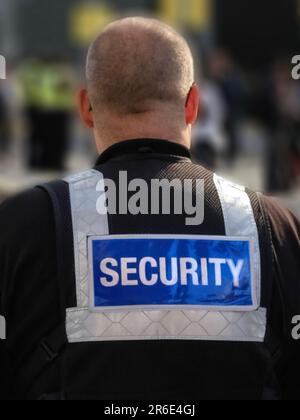 Der Wachmann fotografierte am Bahnsteig Manchester Metrolink und zeigte das Wort "Sicherheit" auf ihrer Uniform. Stockfoto