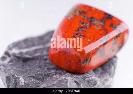 Naturstein-roter Jasper glänzt in wunderschönen Farben auf weißem Hintergrund Stockfoto