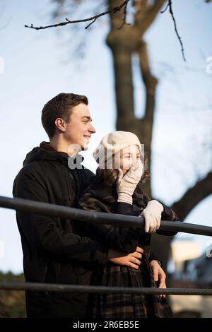 Eine Frau in Mantel und Baskenmütze umarmt den Mann auf den Straßen von Paris im Herbst Stockfoto