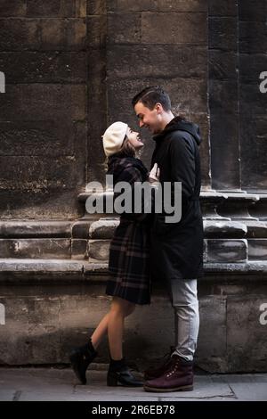 Junger Mann und Frau, die im Herbst auf den Straßen einer europäischen Stadt lachen Stockfoto