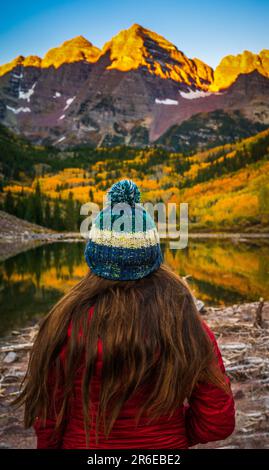 Ein Mädchen, das im Herbst die Maroon Bells in Colorado ansieht Stockfoto