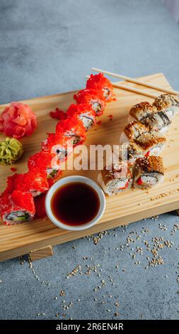 Eine traditionelle japanische Sushi-Platte mit verschiedenen Gemüsesorten und Essstäbchen, serviert auf einem Holztablett Stockfoto