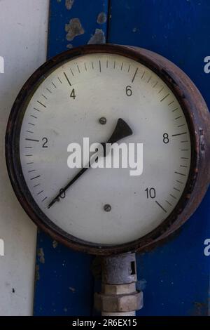 Altes Rundmanometer mit Skala und Pfeilen im Nahbereich. Stockfoto