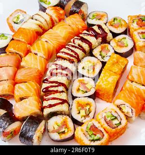 Sushi-Brötchen mit Lachs, Avocado, Frischkäse, Gurke, Reis, Thunfisch auf weißem Hintergrund Stockfoto