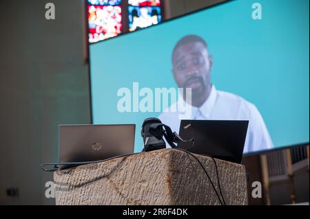 09. Juni 2023, Bayern, Fürth: Die aufgezeichnete Datei des von der KI geschaffenen Dienstes wird mit einem Laptop abgespielt und mit einem Projektor auf eine Leinwand übertragen. In St. Paul Church, ein Service, der von der Chat GPT Artificial Intelligence (AI) erstellt und zuvor aufgezeichnet wurde, wird durchgeführt. Foto: Daniel Vogl/dpa/Alamy Live News Stockfoto
