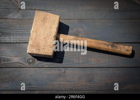 Alter Holzschreinerhammer auf dunklem Holzhintergrund. Stockfoto
