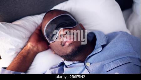 Junger Afrikanischer Mann, Der Mit Schlafmaske Schläft Stockfoto