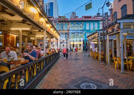 Touristen schlendern durch Chinatown, Singapur, oder essen in den halb offenen Restaurants der Gegend, die sich in renovierten traditionellen alten Häusern befinden Stockfoto
