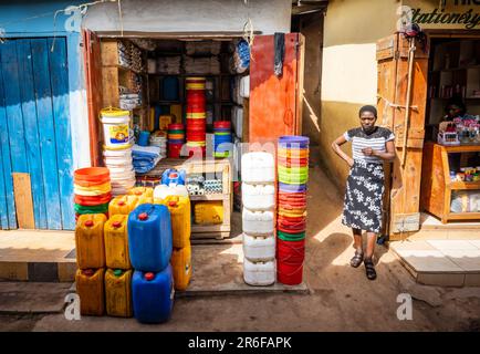 Eine weibliche Marktführerin in Mzuzu, Malawi, steht vor ihrem Plastikwarenladen. Stockfoto