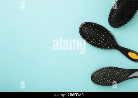 Haarwerkzeuge, Schönheits- und Friseurkonzept – verschiedene Bürsten oder Kämme auf blauem Hintergrund Stockfoto