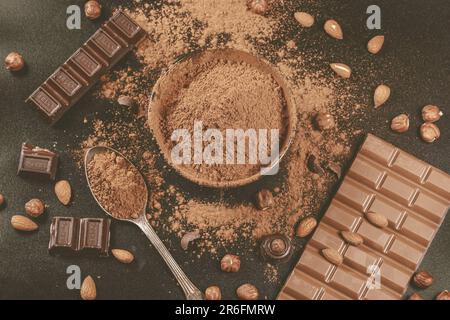 Eine köstliche und abwechslungsreiche Auswahl an Schokolade und Nüssen auf einem Tisch, einschließlich Kakaobar und Kakaopulver, was für einen dekadenten und leckeren Leckerbissen sorgt Stockfoto