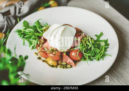 Ein lebendiger, köstlicher Teller mit frischem Obst und Gemüse in kunstvoller Anordnung Stockfoto