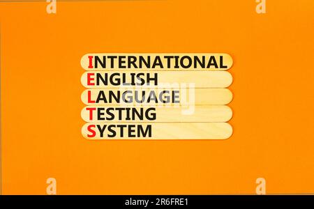 IELTS-Symbol. Konzeptbegriffe IELTS internationales englischsprachiges Testsystem auf Holzstab. Wunderschöner orangefarbener Hintergrund. Business IELTS internati Stockfoto