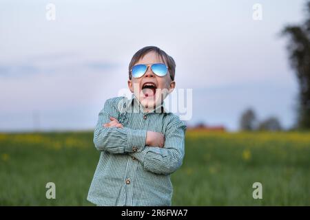 Ein Kind mit Sonnenbrille gibt vor, ein cooler Mann zu sein Stockfoto