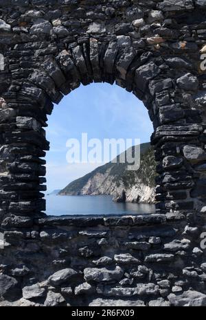 Der herrliche Golf von Lord Byrons Grotte, eingerahmt von den mittelalterlichen Fenstern der Kirche San Pietro in Portovenere. Stockfoto