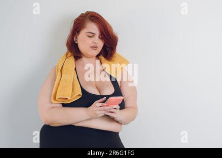 Junge, übergroße, sportliche argentinische Latina-Frau, die telefoniert, auf weißem Hintergrund, Kopierbereich Stockfoto