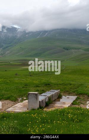 Ein alter Steintrog, der Trinkwasser auf einem einfachen wilden Campingplatz im Apenningebirge, Umbrien, Italien, Europa, bereitstellt Stockfoto