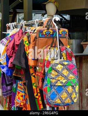 Toronto, Kanada - 4. Juni 2023: Kensington Market. Ein Kleiderständer mit Kleiderbügeln. Afrikanische Stoffbekleidung ist auf dem Regal ausgestellt. Stockfoto