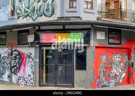 Toronto, Kanada - 4. Juni 2023: Kensington Market. Ein altes Gebäude mit der Beschilderung 'TACOS 477'. An der Wand des Gebäudes befindet sich farbenfrohe Hexenmonsterkunst. Stockfoto